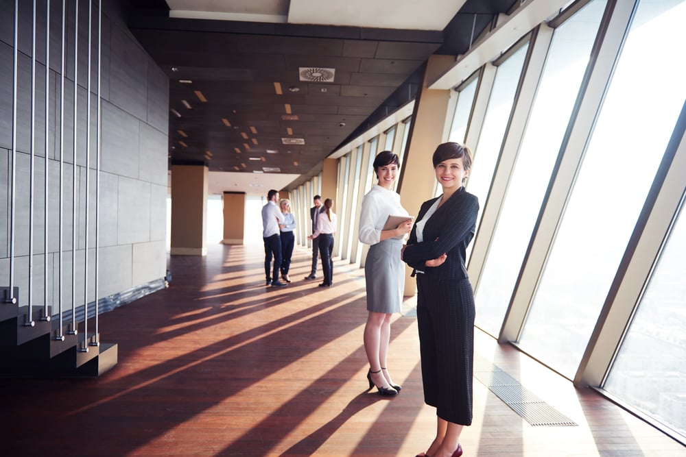 business people group,  females as team leaders standing together  in modern bright office interior